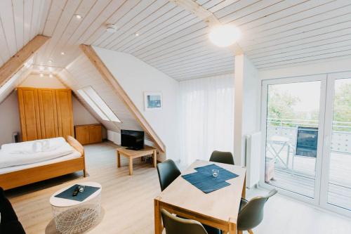 a bedroom with a bed and a table with a desk at Strandpension Mäder in Uhldingen-Mühlhofen