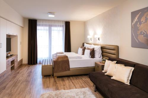 a hotel room with a bed and a couch at Főtér Rezidencia 2 in Győr