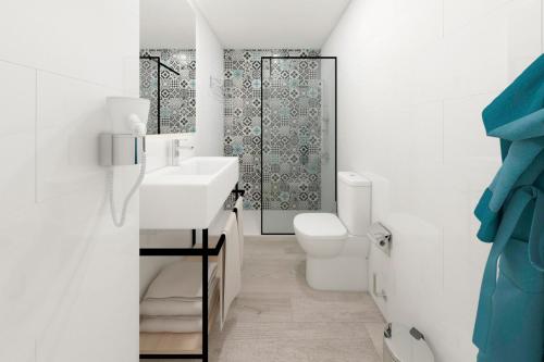 a white bathroom with a sink and a toilet at Palmanova Suites by TRH in Magaluf