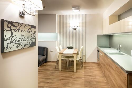 a small kitchen and dining room with a table and chairs at Főtér Rezidencia 2 in Győr