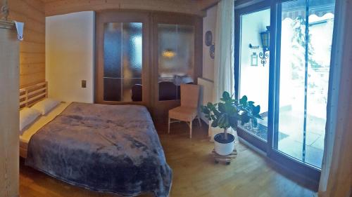 a bedroom with a bed and a potted plant at Apartments Almstein in Abtenau