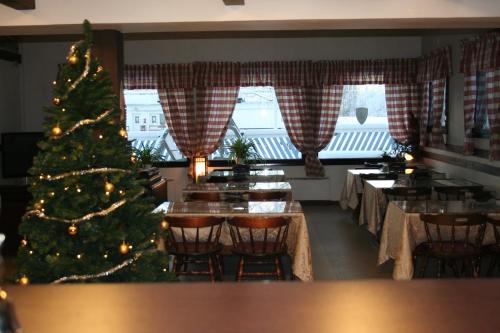 a christmas tree in a restaurant with tables and chairs at Motelli Rovaniemi in Rovaniemi