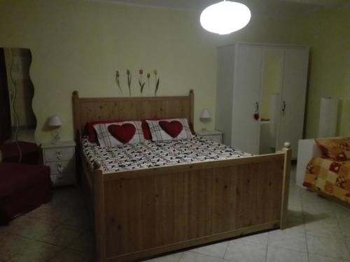 a bedroom with a wooden bed with two hearts on it at Sally's House in Venaria Reale