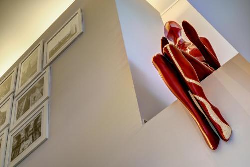 a sculpture of red shoes hanging on a wall at UNA Hotels Mediterraneo Milano in Milan