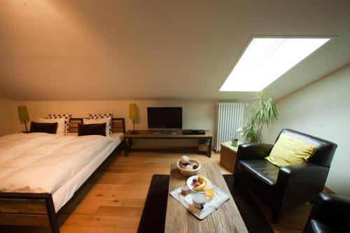 ein Schlafzimmer mit einem Bett, einem Sofa und einem TV in der Unterkunft BnB La Clemonie in Arzier