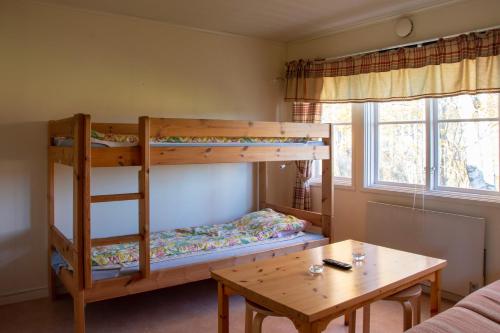 a bunk bed and a table in a room at Älvdalens Camping in Älvdalen