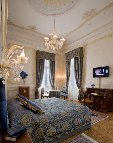 a bedroom with a bed and a chandelier at Hotel Villa Condulmer in Mogliano Veneto
