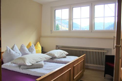 a bedroom with two beds with pillows and a window at Gschwanderhof in Glottertal