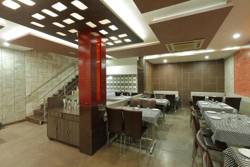 a restaurant with tables and chairs and a staircase at Hotel Good Night in Ahmedabad