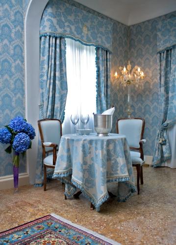 a blue room with a table and chairs and a window at Hotel Villa Condulmer in Mogliano Veneto