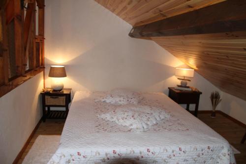 a bedroom with a white bed with two lamps on tables at Grande maison de vacances in Lévignacq