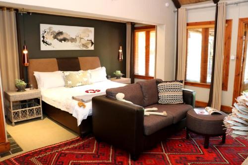a living room with a couch and a bed at Sherewood Lodge in Pretoria