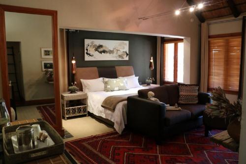 a bedroom with a bed and a couch at Sherewood Lodge in Pretoria