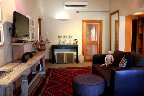 a living room with a couch and a tv at Sherewood Lodge in Pretoria
