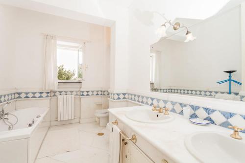 łazienka z 2 umywalkami, lustrem i toaletą w obiekcie Villa Lamaro w mieście Piano di Sorrento