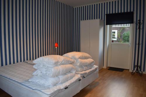 a bedroom with a bed with white sheets and pillows at Åsa Jutegård in Åsa