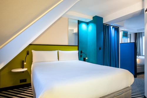 a bedroom with a white bed and a blue door at Hotel Pilime in Paris