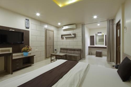 a large room with a bed and a television at Hotel Good Night in Ahmedabad