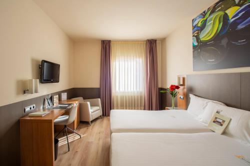 a hotel room with two beds and a desk at Maisonnave in Pamplona