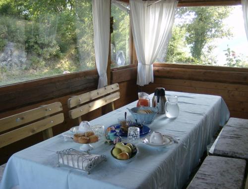 einen Tisch mit einem blauen Tischtuch mit Obst darauf in der Unterkunft Agriturismo Al Respiro Nel Bosco in Camporotondo di Fiastrone