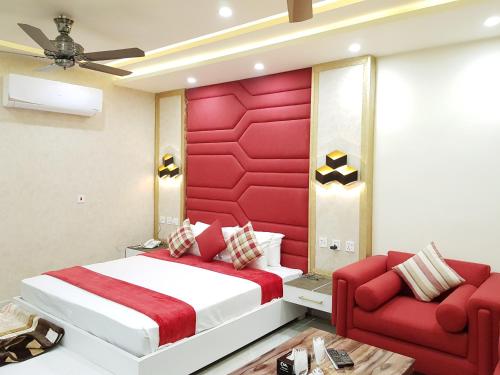 a bedroom with a red headboard and a red couch at Hotel Avalon Suites in Multan