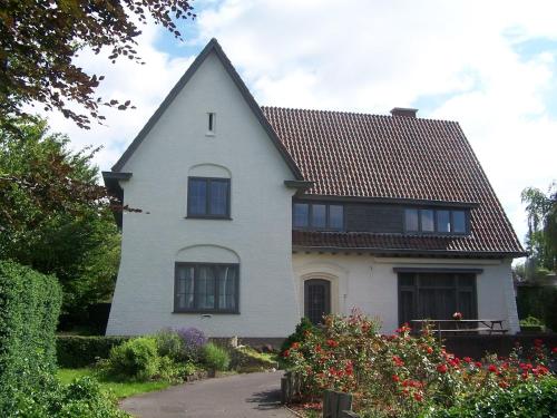 a white house with a gambrel roof at Classic Mansion in Poperinge with Fenced Garden in Poperinge