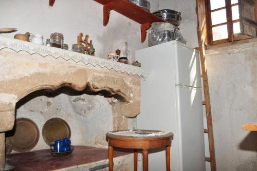 a kitchen with a refrigerator and a table and a stove at Old Traditional House in the Castle of Monenvasia in Monemvasia