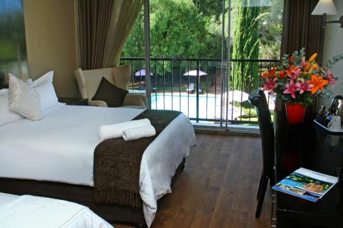 a hotel room with a bed and a balcony at Oudtshoorn Inn Hotel in Oudtshoorn