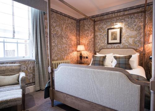 a bedroom with a bed with ornate wallpaper at The Beverley Arms Hotel in Beverley