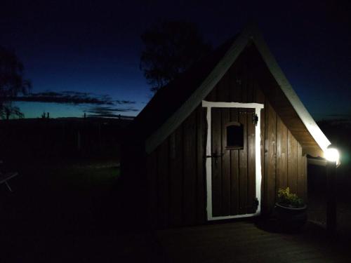 a small building with a door in the dark at Macbeth's Hillock in Forres