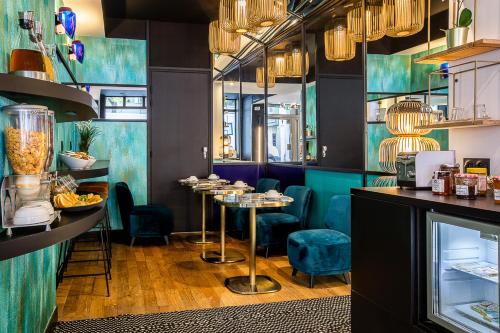 un restaurant avec des chaises et des tables bleues dans une salle dans l'établissement Hotel Pilime, à Paris