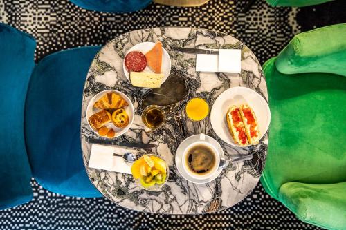 a table with plates of food on top of it at Hotel Pilime in Paris