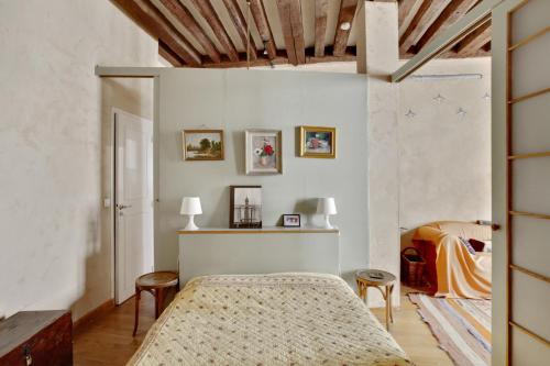 - une chambre avec un lit et deux tabourets dans l'établissement Marais-Rue des Rosiers ID 24, à Paris