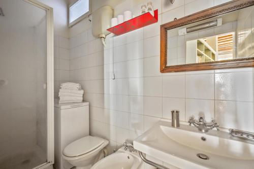 une salle de bain avec toilettes, lavabo et miroir dans l'établissement Marais-Rue des Rosiers ID 24, à Paris