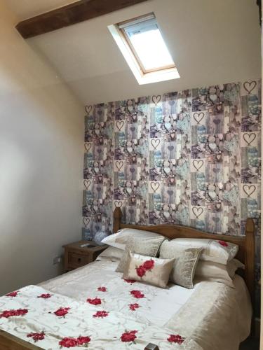 ein Schlafzimmer mit einem Bett mit roten Blumen darauf in der Unterkunft Beautiful Wales in Barmouth