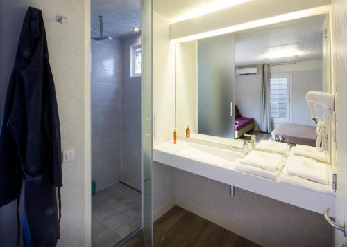 a bathroom with a sink with a mirror and a shower at Fabulous village in Casal Palocco