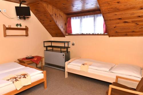 Habitación con 2 camas y TV. en Chata Slunečná en Jestrabi V Krkonosich