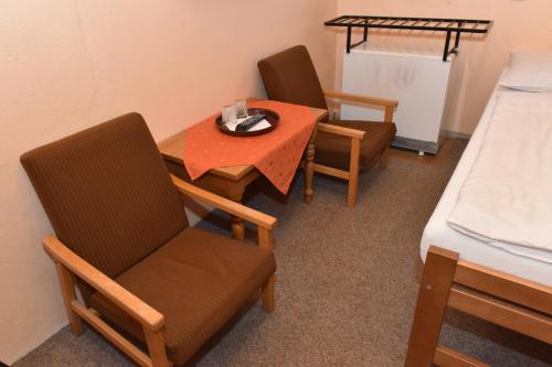 Jestrabi V KrkonosichにあるChata Slunečnáのテーブル、椅子、ベッドが備わる客室です。