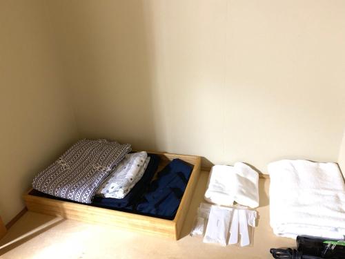 a small room with a bed and two towels at Hokkai Hotel in Lake Toya