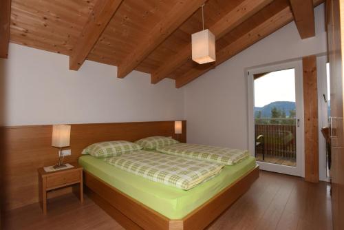 a bedroom with a bed and a large window at Haus Waldruhe in Villandro