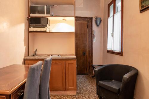 een keuken met een tafel en stoelen en een tafel en een aanrecht bij Ca’Molin in Venetië