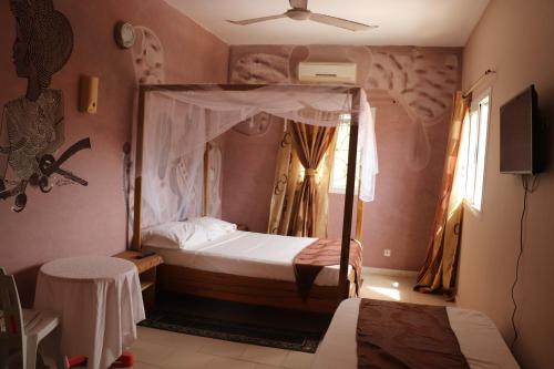 a bedroom with a bed with a canopy at Africa 6 Plage in Somone