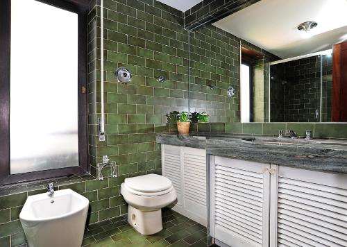 ein Badezimmer mit einem WC, einem Waschbecken und einem Spiegel in der Unterkunft Sunset Balcony in Estoril - Checkinhome in Estoril