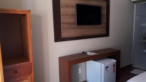 a room with a television and a small refrigerator at Estalagem do Carmo in Pirenópolis