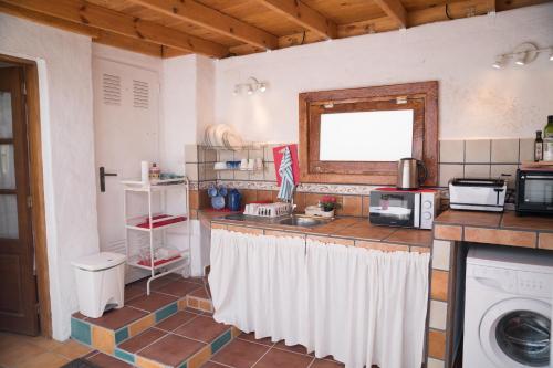 a kitchen with a counter with a sink and a washing machine at El Cerro de la Luna in Arona