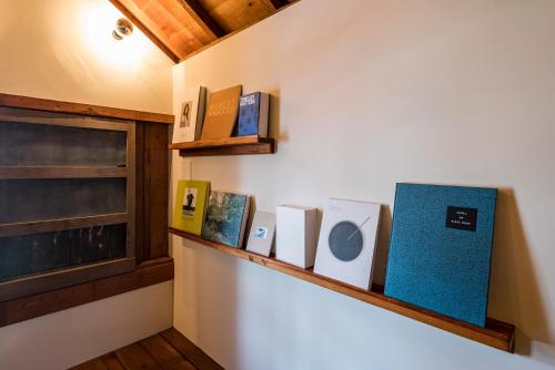 a shelf with books on a wall at The Bath & Bed Hayama in Hayama