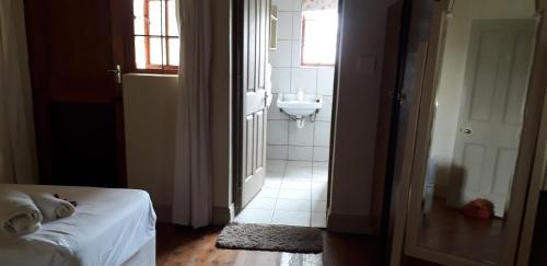 a bedroom with a bed and a bathroom with a sink at Disa Lodge in Darling