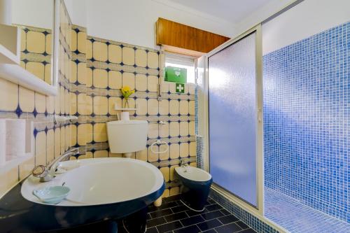 La salle de bains est pourvue d'un lavabo, de toilettes et d'une douche. dans l'établissement Casa da Esquina - Faro city center, à Faro