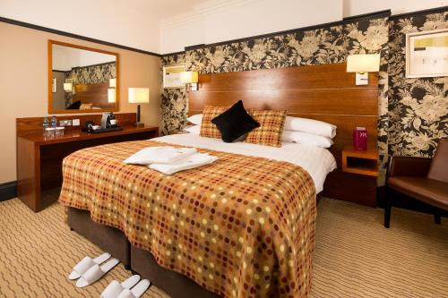 a hotel room with a large bed and a mirror at Mercure Norwich Hotel in Norwich