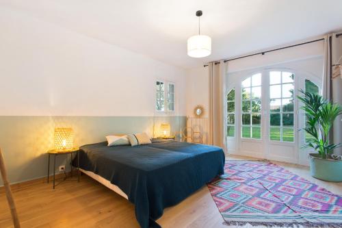 une chambre avec un lit et une grande fenêtre dans l'établissement Etche Churria, à Urrugne